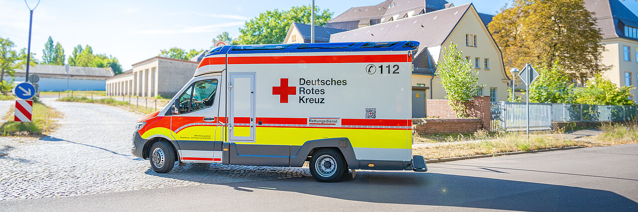 DRK-RTW, BRG-83/1 Neuer DRK-Rettungswagen RTW 83/1 in Burg, Seitenansicht auf der Straße, Beschriftung „Deutsches Rotes Kreuz“ und Notruf 112 sichtbar