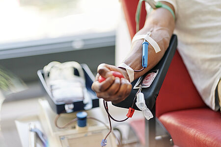 DRK-Blutspende Arm einer Person während der Blutspende beim DRK, im Vordergrund die Blutbeutel und das medizinische Equipment.